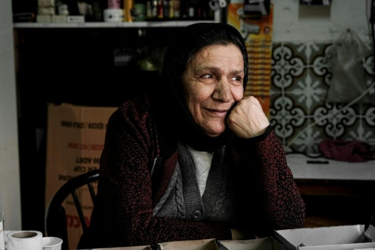 Portret starszej kobiety o wyrazistych rysach twarzy, ciemnych oczach i oliwkowej cerze. Cechy często utożsamiane z sefardyjskim typem urody.